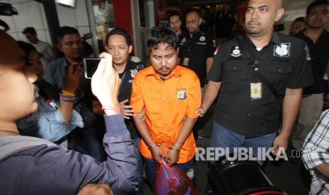 Polisi mengawal tersangka pelaku pembunuhan terhadap mantan wartawan Abdullah Fithri Setiawan alias Dufi, berinisial MN, seusai penangkapan di Polda Metro Jaya, Jakarta, Rabu (21/11). 