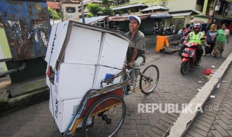 Polisi mengawal tukang becak yang mengangkut logistik hasil Pemilu 2019 di Rusun Sumbo, Surabaya, Jawa Timur, Kamis (18/4/2019).