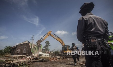 Polisi mengawasi proses pembongkaran rumah pada pengosongan lahan untuk pembangunan New Yogyakarta International Airport (NYIA) di Kulonprogo, DI Yogyakarta, Senin (4/11). 