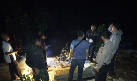 Polisi mengecek kondisi makam yang terbuka sebagian di TPU Kampung Pakemitan II, Desa Pakemitan, Kecamatan Cikatomas, Kabupaten Tasikmalaya, Jumat (8/11) malam. 