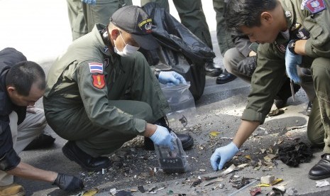 Polisi Thailand memeriksa puing-puing bekas ledakan bom di Bangkok , Thailand , Selasa, (18/8).