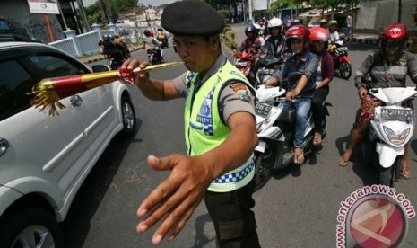 Polisi menggunakan terompet mengatur lalu lintas