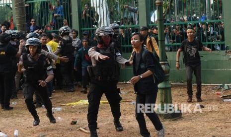 Polisi menghalau massa saat kericuhan dalam unjuk rasa di depan kompleks Parlemen di Jakarta, Selasa (24/9/2019). 