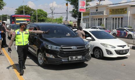 Polisi menghentikan kendaraan yang akan menuju Pulau Madura di akses masuk Jembatan Suramadu, Surabaya, Jawa Timur, Rabu (9/6/2021). Pihak kepolisian meminta pengendara untuk kembali dan tidak bepergian ke Pulau Madura jika tidak mempunyai keperluan yang penting menyusul meningkatnya jumlah kasus COVID-19 di Bangkalan, Madura. 