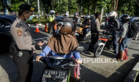 Polisi mengimbau pengendara motor berboncengan saat pemberlakuan PSBB.