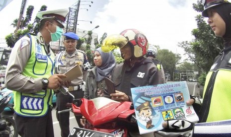 Polisi mengingatkan pengendara motor yang boncengannya tidak menggunakan helm saat pelaksanaan 'Operasi Simpatik Lodaya' 