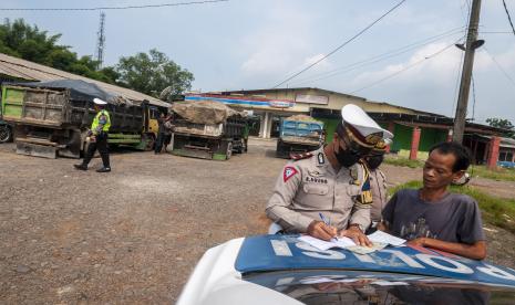 Polisi menilang pengemudi kendaraan truk bermuatan lebih yang terjaring razia di Citeras, Lebak, Banten, Selasa (7/6/2022). Razia yang menyasar truk yang memiliki dimensi dan muatan berlebih (over dimension overload) dan truk pasir basah tersebut bertujuan untuk meningkatkan ketertiban pengguna jalan sekaligus mengurangi resiko kecelakaan dalam berkendara. 