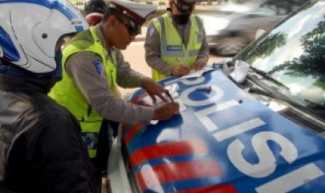 Polisi menindak seorang pengendara sepeda motor yang melanggar aturan lalu lintas dalam Operasi Patuh Jaya.