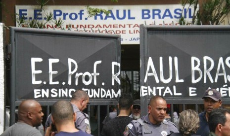 Polisi menjaga pintu masuk sekolah Raul Brasil State School di Suzano, Brasil, Rabu (13/3), setelah terjadi penembakan massal di sekolah tersebut.