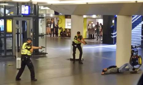 Polisi menodongkan senjata pada tersangka penusuk dua turis AS di stasiun sentral Amsterdam, Jumat (31/8).