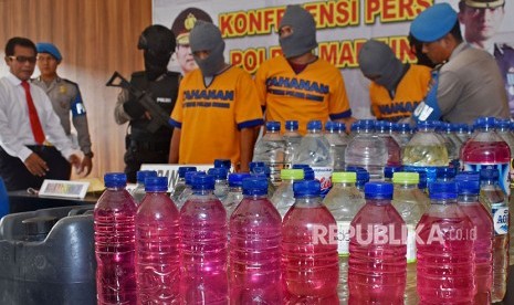 Polisi menunjukkan barang bukti minuman keras (miras) dalam botol bekas kemasan air mineral / Ilustrasi 