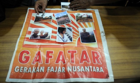 Polisi menunjukkan foto satu keluarga yang hilang berikut atribut bendera Gerakan Fajar Nusantara (Gafatar) di Mapolresta Depok, Jawa Barat, Selasa (19/1).