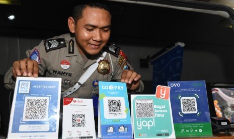 Polisi menunjukkan sejumlah layanan QR code yang terdapat di pelayanan SIM Keliling disela-sela peluncuran program 'Cashless Payment PNBP SIM dan SKCK di Polrestabes Surabaya, Jawa Timur, Sabtu (1/12/2018). 