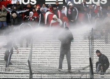 Polisi menyemprotkan air ke arah suporter River Plate yang merusak fasilitas Stadion Monumental usai tim kesayangannya terdegradasi.