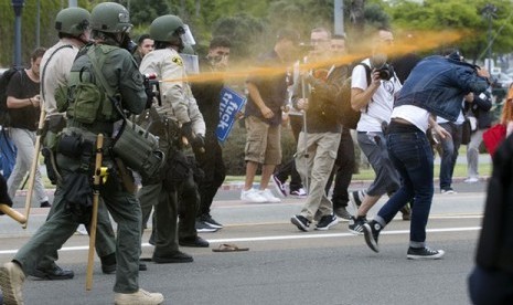 Polisi menyemprotkan cairan merica ke arah demonstran yang berunjuk rasa saat kampanye calon presiden AS Donald Trump di San Diego, Jumat, 27 Mei 2016.