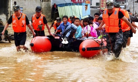 Polisi paramiliter Cina mengevakuasi korban banjir akibat hujan lebat di Heyuan, Guangdong, Senin (10/6). 