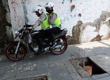 Polisi pengendara sepeda motor menggunakan trotoar untuk menghindari kemacetan di jalan raya, Jakarta, Selasa (21/2). (Republika/Aditya Pradana Putra)