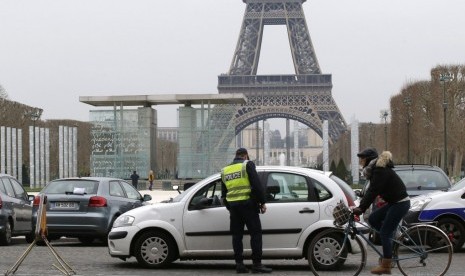 Polisi Prancis memeriksa kendaraan yang melintas di kawasan Menara Eiffel, Paris. 