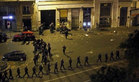 Polisi Prancis mengenakan tameng berbaris di dekat Bataclan Concert Hall, area tempat salah satu insiden penembakan dan pengeboman terjadi di Paris, Prancis, Sabtu (14/11).