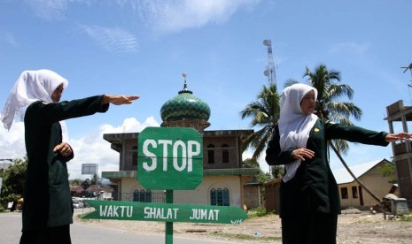 Polisi Syariat (Wilayathul Hisbah) wanita menjaga persimpangan dan mengalihkan jalur lalu lintas di kawasan yang berdekatan dengan masjid saat pelaksanaan ibadah shalat Jumat di Desa Meudang Ara, Blangpidie, Aceh Barat Daya, NAD, Jumat (25/10).   (Antara/I