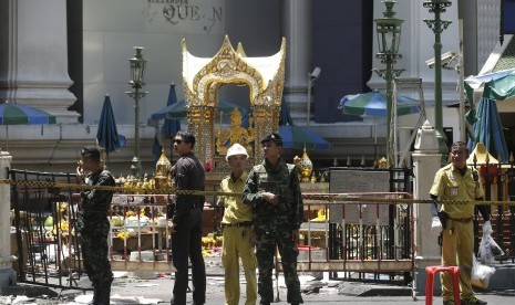  Polisi , tentara , dan para pejabat lainnya bekerja di dekat patung Phra Phrom , interpretasi Thailand dewa Hindu Brahma , di Erawan Shrine di Rajprasong persimpangan hari setelah ledakan di Bangkok , Thailand , Selasa, 18 Agustus, 2015 .