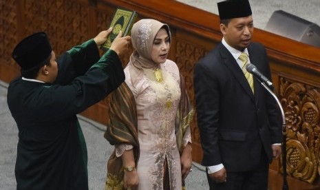 Politisi Partai Golkar Marlinda Irwanti (tengah) bersama Politisi PKS Sutriyono (kanan) disumpah sebagai Anggota DPR Pergantian Antarwaktu (PAW) dalam Sidang Paripurna. 