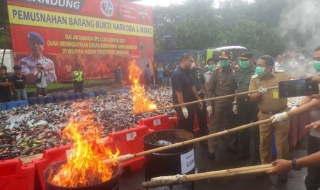 Polrestabes Bandung memusnahkan barang bukti 12 kilogram sabu, 843 batang pohon ganja, 18 ribu lebih minuman beralkohol dan 13 jerigen tuak di depan mapolrestabes Bandung, Senin (30/12).