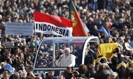 Pope Benedict XVI waves to the faithful as he arrives in St Peter's Square to hold his last general audience at the Vatican February 27, 2013. 