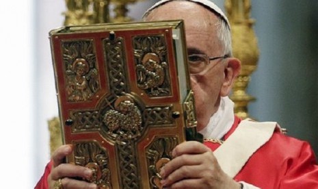 Pope Francis holds the book of the gospels as he celebrates a mass of Pentecost in St. Peter's Basilica, at the Vatican, Sunday, June 8, 2014. 