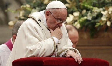 Pope Francis kneels as he leads the Christmas night mass in Saint Peter's Basilica at the Vatican December 24, 2014.