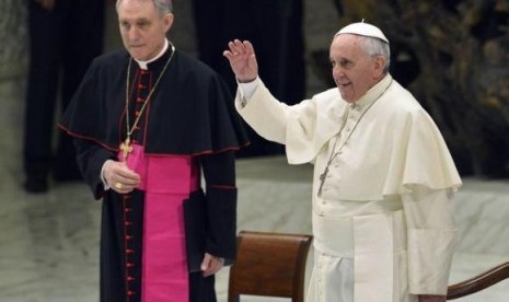 Pope Francis (right), flanked by Archbishop Georg Ganswein, waves as he arrives to lead his Wednesday general audience at the Vatican August 6, 2014.