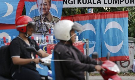 Poster kampanye Mahathir Mohamad ditampilkan di sepanjang jalan di Kuala Lumpur, Malaysia pada Kamis (10/5). Hasil resmi dari pemilihan nasional Malaysia menunjukkan aliansi oposisi yang dipimpin oleh Mahathir Mohamad telah memenangkan kursi mayoritas di parlemen, mengakhiri kekuasan 60 tahun Barisan Nasional.