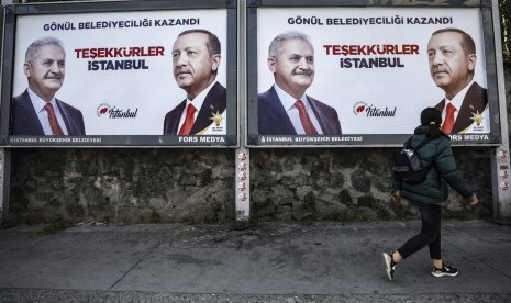 Poster yang menunjukkan gambar diri kandidat wali kota Istanbul Binali Yildirim (kiri) dan Presiden Turki Recep Tayyip Erdogan yang merupakan pemimpin AK Party, sehari setelah pemilihan lokal di Istanbul, Senin (1/4). 