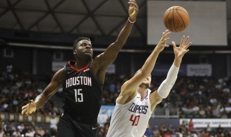 Power forward Houston Rockets, Clint Capela (kiri) dan Center Los Angeles Clippers, Ivica Zubac, berebut bola dalam pertandingan pramusim basket NBA di Honolulu, Hawaii, Kamis (3/10).