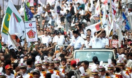 Prabowo-Hatta melambaikan tangan menyapa simpatisan saat kampanye akbar di Gelora Bung Karno, Jakarta, Ahad (22/6).