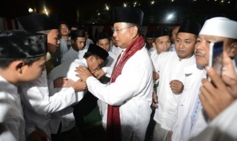 Prabowo Subianto bersalaman dengan warga saat buka bersama anak yatim dan warga sekitar di kediaman Hambalang, Bogor, Jabar, Selasa (8/7).