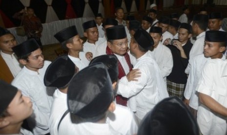 Prabowo Subianto bersalaman dengan warga saat buka bersama anak yatim dan warga sekitar di kediaman Hambalang, Bogor, Jabar, Selasa (8/7).