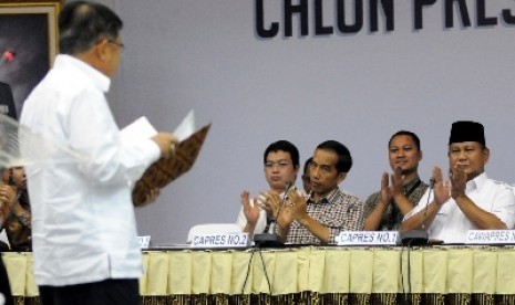 Prabowo Subianto (kanan) dan Joko Widodo (ketiga kanan) memberi tepuk tangan usai Jusuf Kalla membacakan laporan harta kekayaan di Kantor KPU, Jakarta, Selasa (1/7). 