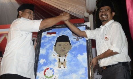 Prabowo Subianto (kiri) mendapatkan cinderamata lukisan dari Ketua Barisan Nusantara Jaya Gus Ais (kanan) saat silaturahmi bersama relawan di Surabaya, Jatim, Rabu (16/7). 