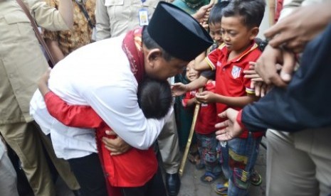 Prabowo Subianto memeluk seorang anak saat mengunjungi kontrakan seribu pintu di kawasan industri Jababeka, Cikarang, Bekasi, Jabar, Senin (7/7). 