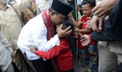 Prabowo Subianto mencium kening seorang anak saat mengunjungi kontrakan seribu pintu di kawasan industri Jababeka, Cikarang, Bekasi, Jabar, Senin (7/7). 