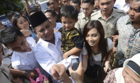 Prabowo Subianto menggendong anak kecil seusai menggunakan hak pilihnya di TPS 02, Bojong Koneng, Bogor, Jabar, Rabu (9/2). 