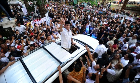 Prabowo Subianto menyapa relawan saat akan meninggalkan rumah Polonia, Jakarta, Selasa (22/7).