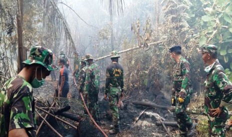 Prajurit Lanal Ranai membantu masyarakat Dusun Setengar, Natuna, yang mengalami kebakaran hutan, baru-baru ini.  