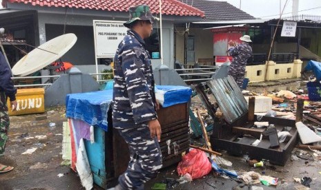 Prajurit TNI AL membersihkan puing-puing di sekitar Pos Pengamatan TNI AL Labuan, Kampung Nelayan I, Desa Teluk, Kecamatan Labuan, Kabupaten Pandeglang, Banten, Senin (24/12).