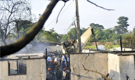 Prajurit TNI AU berada didekat bangkai pesawat Fokker 27 yang jatuh di sekitar kompleks perumahan Halim Perdanakusuma, Jakarta, Kamis (21/6).