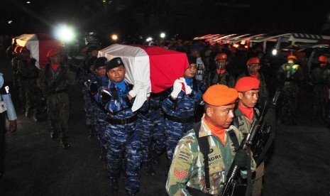 Prajurit TNI AU menggotong peti jenazah korban kecelakaan pesawat Hercules A-1334 untuk disemayamkan di Hanggar Skadron 32 Lanud Abdulrahman Saleh, Malang, Jawa Timur, Minggu (18/12) malam. 