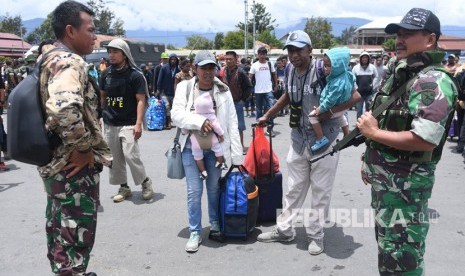 Prajurit TNI berjaga di antara warga yang gagal berangkat untuk mengungsi dengan menumpang pesawat Hercules TNI AU di Bandar Udara Wamena, Papua, Rabu (9/10/2019).