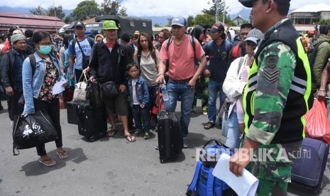 Prajurit TNI berjaga di antara warga yang gagal berangkat untuk mengungsi dengan menumpang pesawat Hercules TNI AU di Bandar Udara Wamena, Papua, Rabu (9/10/2019).