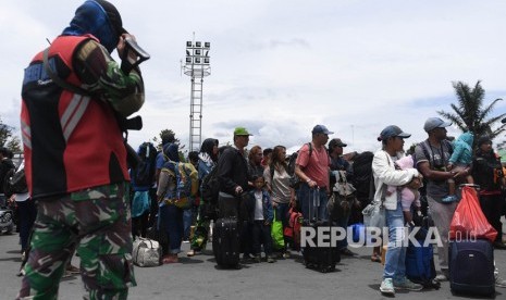 Prajurit TNI berjaga di antara warga yang gagal berangkat untuk mengungsi dengan menumpang pesawat Hercules TNI AU di Bandar Udara Wamena, Papua, Rabu (9/10/2019).